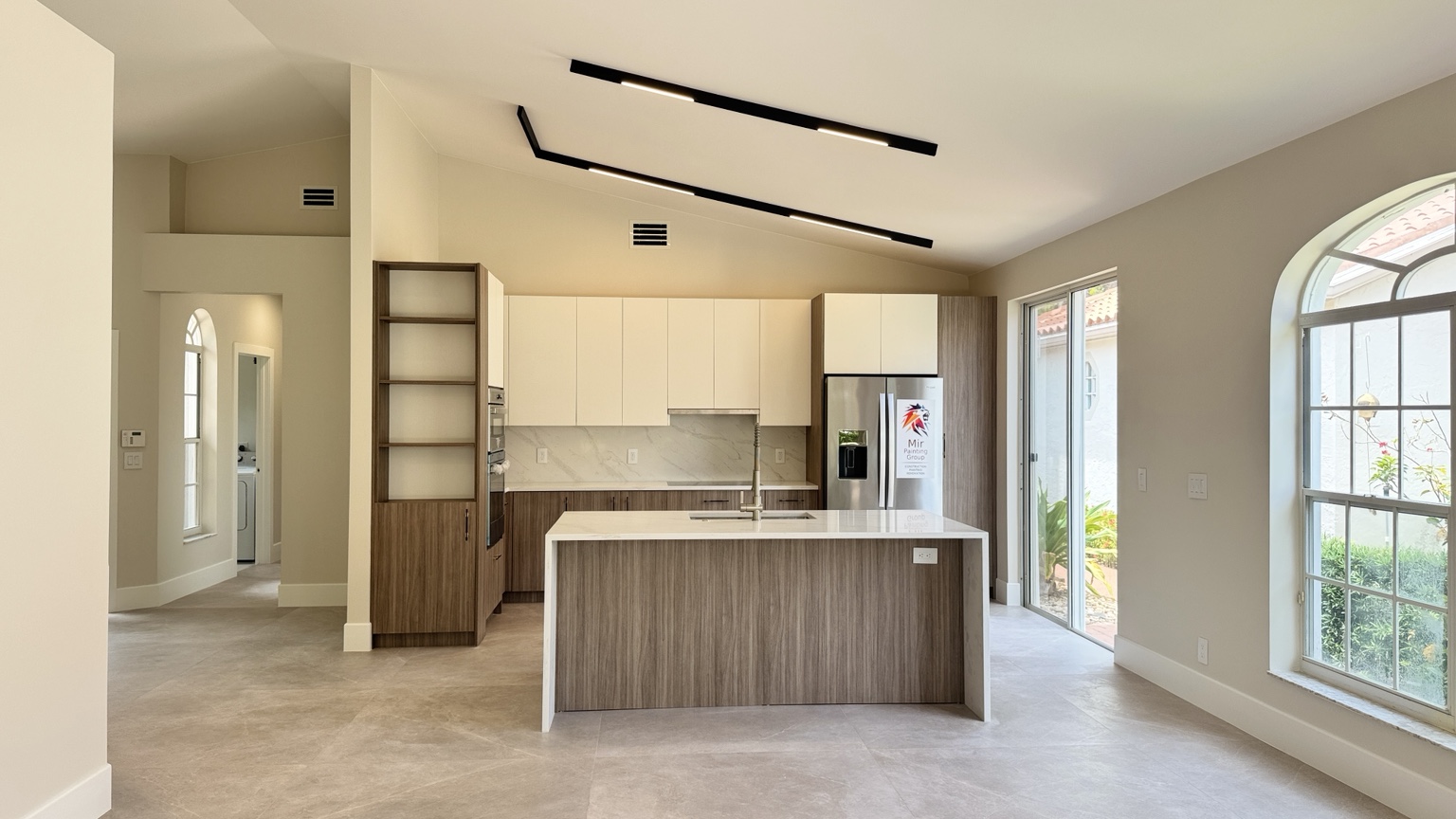 Modern kitchen and open living area with smooth wall and ceiling finishes